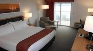 a hotel room with a bed and a chair at Holiday Inn Express Munising-Lakeview Hotel By IHG in Munising +33 photos