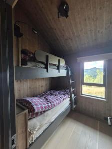 a bedroom with bunk beds in a tiny house at Modern mountain cabin with panorama view in Eggedal