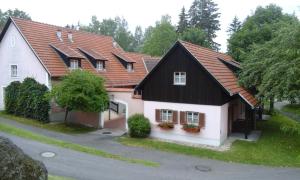 ein Haus mit schwarzem Dach und weiß in der Unterkunft Haus am See in Litschau