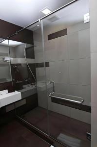 a bathroom with a glass shower and a sink at Hotel 61 Medan in Medan