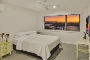 Una habitación blanca con una cama y una ventana en Waterfront-Bay View, en Port Macquarie