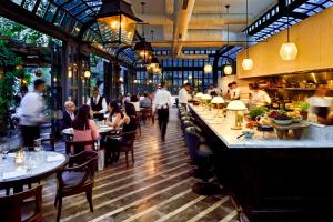 a restaurant with people sitting at tables and a bar at Soho House Istanbul in Istanbul