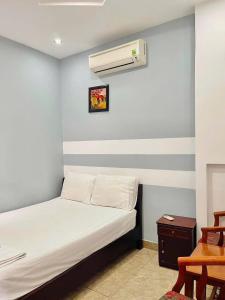 a bedroom with a bed with a air conditioner on the wall at Cát Tường Homestay in Danang +2 photos