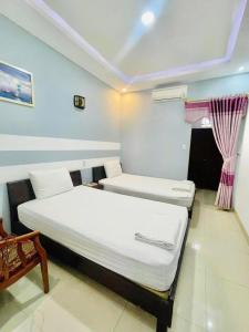 a room with two beds and a window at Cát Tường Homestay in Danang