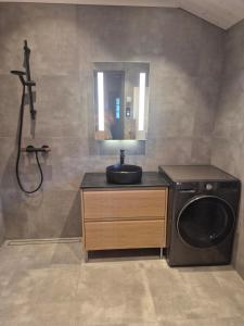 a bathroom with a washing machine and a sink at Modern mountain cabin with panorama view in Eggedal +25 photos