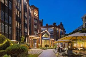 a building with a clock tower on top of it at Hangzhou Cosy Park Hotel in Hangzhou