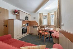 a kitchen with a couch and a table in a room at Ferienwohnungen Haus Daheim in Längenfeld