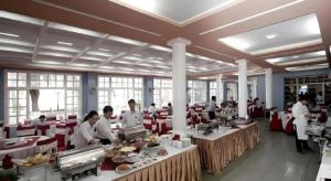 a group of people preparing food in a restaurant at Hai Au Hotel in Ðông Thôn