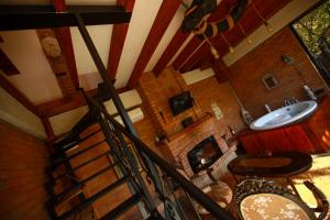 a room with a staircase and a sink and a fireplace at Villa Vejini cabin in Mamkoda
