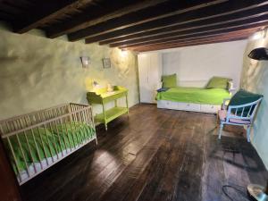 a bedroom with a green bed and a crib at Große Finca 19Jh, Pool, Terrasse, nahe Santa Cruz in Santa Cruz de la Palma +26 photos