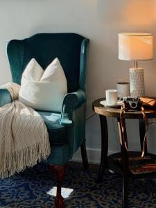 una silla verde sentada junto a una mesa con una lámpara en Downtown 4B2B Apt, Walk to PPAC & Convention Center, en Providence