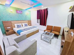 a hotel room with a bed and a couch at Hotel Goodwill Stay Near Delhi Airport in New Delhi