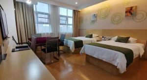 une chambre d'hôtel avec deux lits, une table et un bureau dans l'établissement GreenTree Inn Shangrao Yueliangwan Automobile City, à Shangrao County