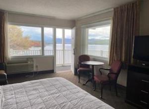 Una habitación de hotel con una cama y vista al océano. en The Georgian Resort, en Lake George