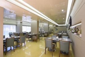 a restaurant with tables and chairs in a room at Ramada by Wyndham Downtown Beirut in Beirut