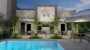 a hotel with a swimming pool in front of a building at The Fig Central Apartments in Gaborone