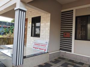 a building with a sign on the side of it at The Homely Stay - Chandransh Homestay in Udupi