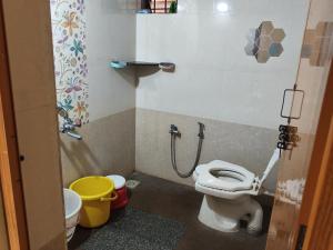 a small bathroom with a toilet and a shower at The Homely Stay - Chandransh Homestay in Udupi +8 photos