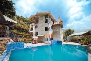 甘托克Bambi Farmstay的一栋楼前有游泳池的别墅
