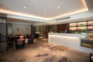 a restaurant with a bar and tables and chairs at Kyriad Marvelous Hotel Xiangyin Bus Station in Xiangyin