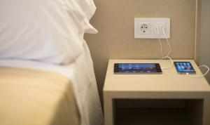 a bed with a remote control on a bedside table at Sono House in La Garriga