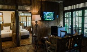 Un dormitorio con una cama y un comedor con una mesa. en Menjangan Ecolodge - CHSE Certified, en Banyuwedang 50 fotos más
