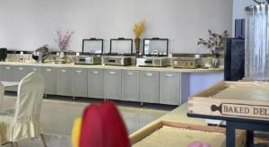 a kitchen with a counter with several sinks and a table at Jinjiang Inn Yangzhou Passenger East Terminal in Yangzhou