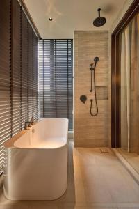 a bathroom with a white tub and a shower at Antara Genting by COBNB - Antara AIR Genting Highlands in Genting Highlands