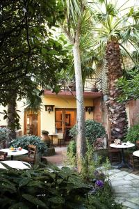 a courtyard with tables and chairs and a palm tree at Hotel Empress Zoe in Istanbul