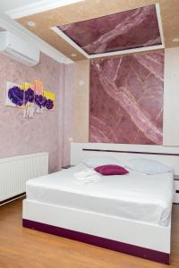 a bedroom with a white bed and a painting on the wall at Nairi in Shahumyan