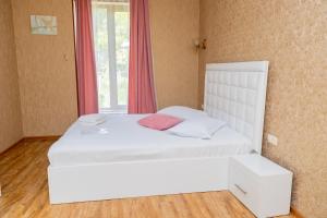 a white bed in a room with a window at Nairi in Shahumyan