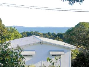 a white building with trees in the background at Vista at Straddie View in Dunwich