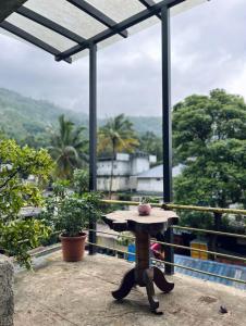 a table with a hat on top of a balcony at Mangattu Salkara highway view retreat in Anniyartholu