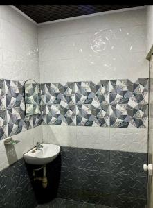 a bathroom with a sink and a tiled wall at Mangattu Salkara highway view retreat in Anniyartholu