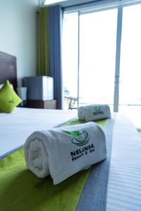 Una toalla en una cama en una habitación de hotel. en Nelinsa Resort and Ayurveda Wellness Center, en Matale