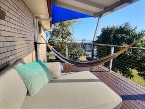 a white couch on a balcony with a hammock at Vista at Straddie View in Dunwich