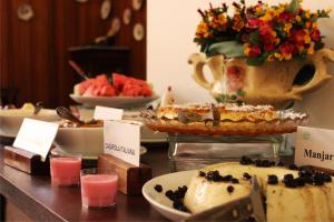 a buffet with cakes and desserts on a table at Avenida Charme Hotel in Águas de São Pedro +238 photos