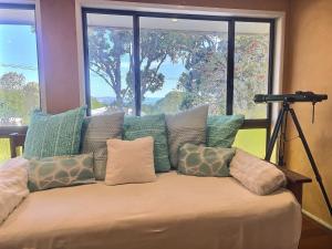 a large bed with pillows and a camera on a tripod at Vista at Straddie View in Dunwich