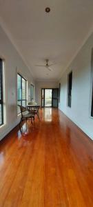 an empty living room with a wooden floor and tables at JNSi Appartments in Honiara