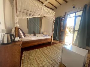 a bedroom with a bed with a canopy at Zanzibar beach escape 1&2 in Bwejuu