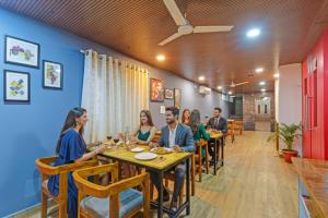 a group of people sitting at a table in a restaurant at FabHotel Rio - Nr Ramoji Filmcity, LB Nagar in Hyderabad