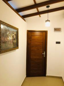 a room with a wooden door and a painting on the wall at Sinharaja Cottage in Nelluwa