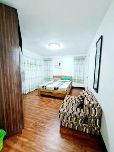 a bedroom with a bed and a couch in a room at Panglao Ramyer Villa 1 in Sampong