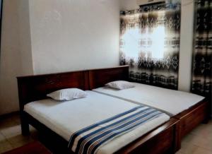 a bed with two pillows on it in a room at Sinharaja Cottage in Nelluwa