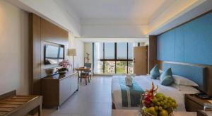 a bedroom with a large bed with a bowl of fruit at Da Peng Zhongzhou Hotel in Haikou