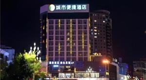 a tall building with a sign on it at night at City Comfort Inn Kunming Cuihu Hospital of Yunnan University Panjiawan Metro Station in Kunming