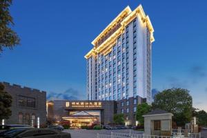 a tall building with a crane on top of it at Jin Jiang Mingcheng Hotel in Yancheng