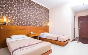 a bedroom with two beds and a wall mural at Hotel Bintang in Palur +65 photos
