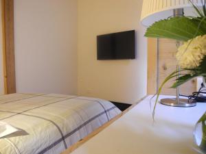 a bedroom with a bed and a tv on the wall at L'Ours in Bischwiller