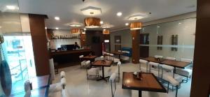 ディポログにあるHotel Camila 2のテーブルと椅子とバーのあるレストラン